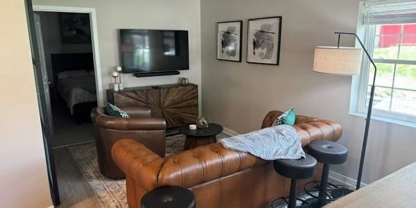 Cozy living room with leather sofas and floor lamp.
