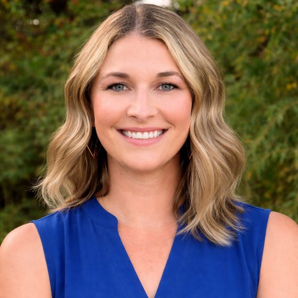 Smiling woman with blonde hair in a blue top.
