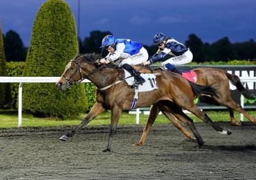Two horses racing neck-and-neck with jockeys in blue and white silks.