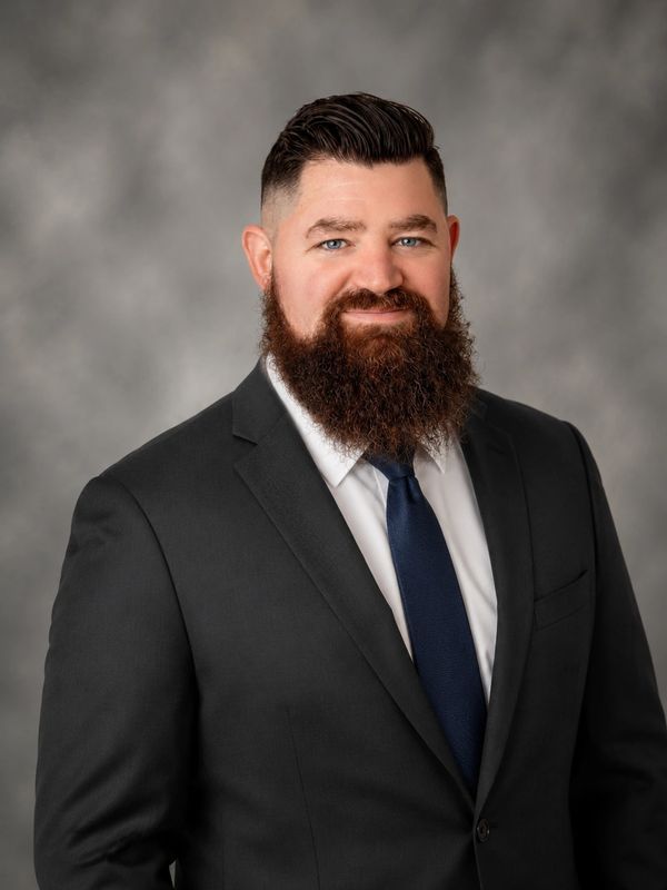 Man with a beard in a suit and tie.