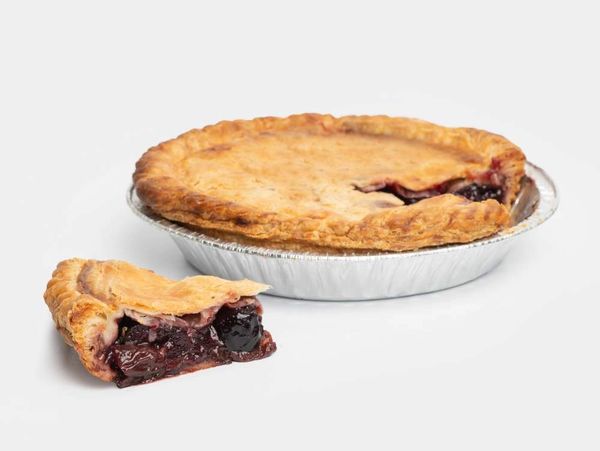 A fruit pie with a flaky, golden crust, shown whole and with one slice removed.