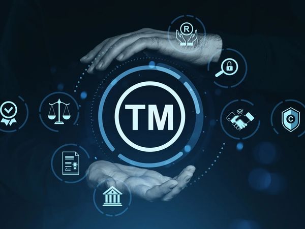 Hands protecting a trademark symbol surrounded by legal icons.