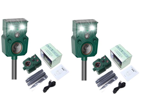 Two identical green ultrasonic animal repellers with accessories.