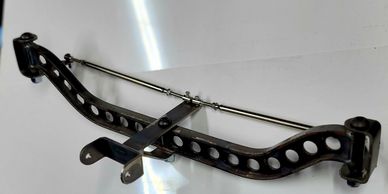 Metal automotive suspension component with perforated design.