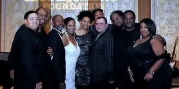 Group of people dressed formally at an event posing for a photo.