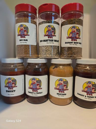 Various BBQ sauces and seasoning jars on a table.