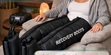Person wearing recovery boots for leg therapy while sitting.