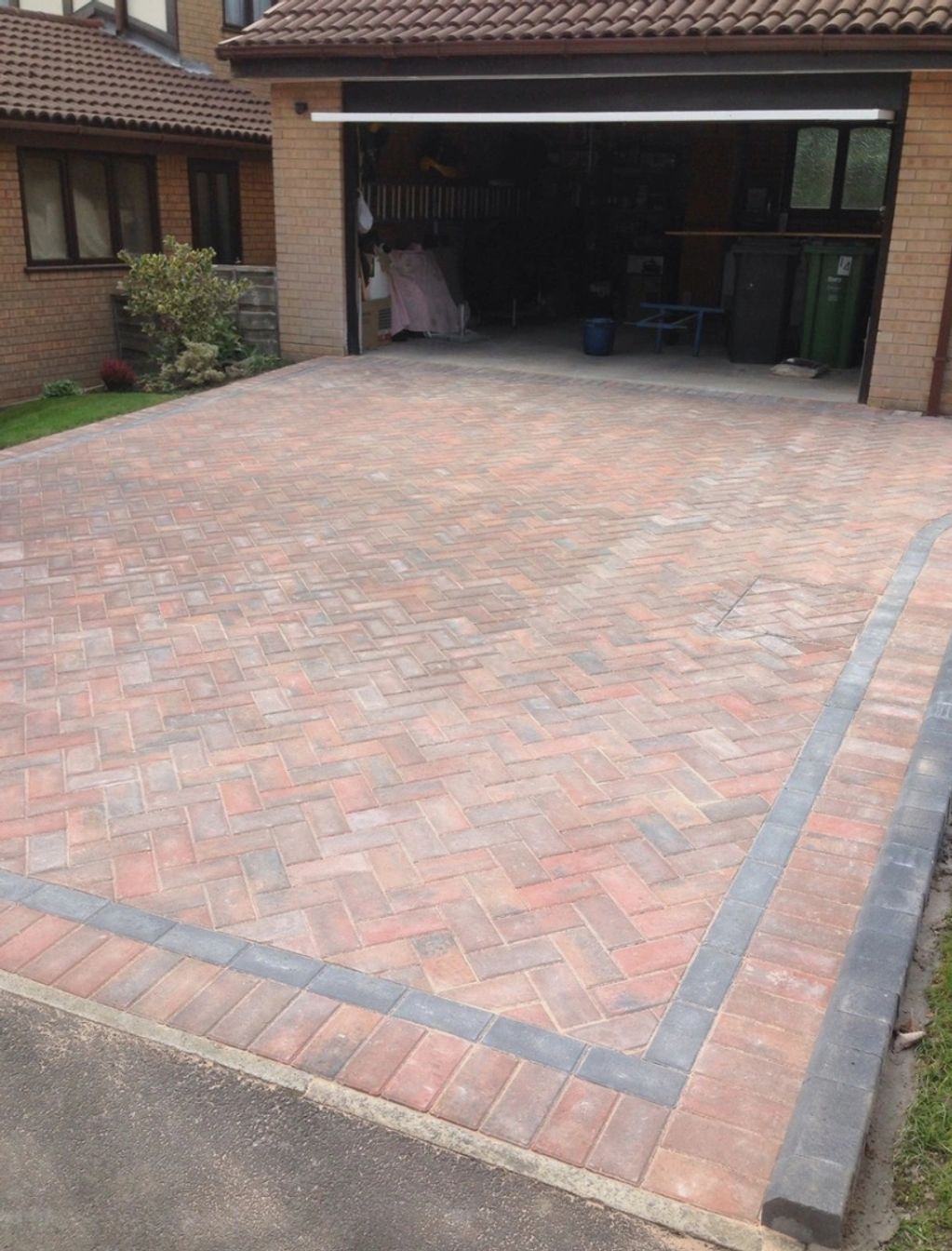 Newly paved brick driveway leading to an open garage.