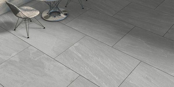 Modern gray stone tile flooring with two chairs in a minimalist setting.