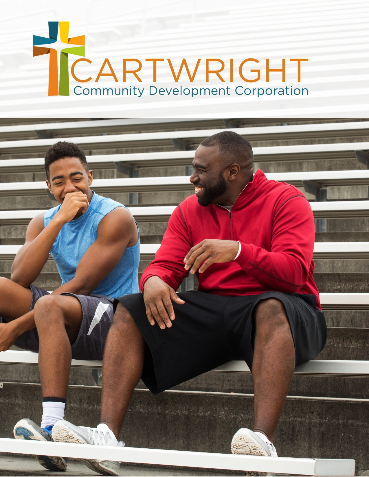 Two men laughing together on stadium bleachers, showcasing community and bonding.