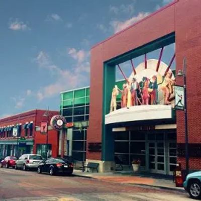 Street view of a theater with colorful statues above the entrance.