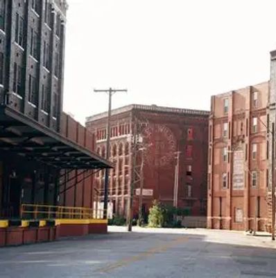 Empty urban street surrounded by old brick buildings under bright sky.