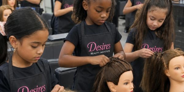 Young girls practicing hairstyling on mannequins at a beauty institute.