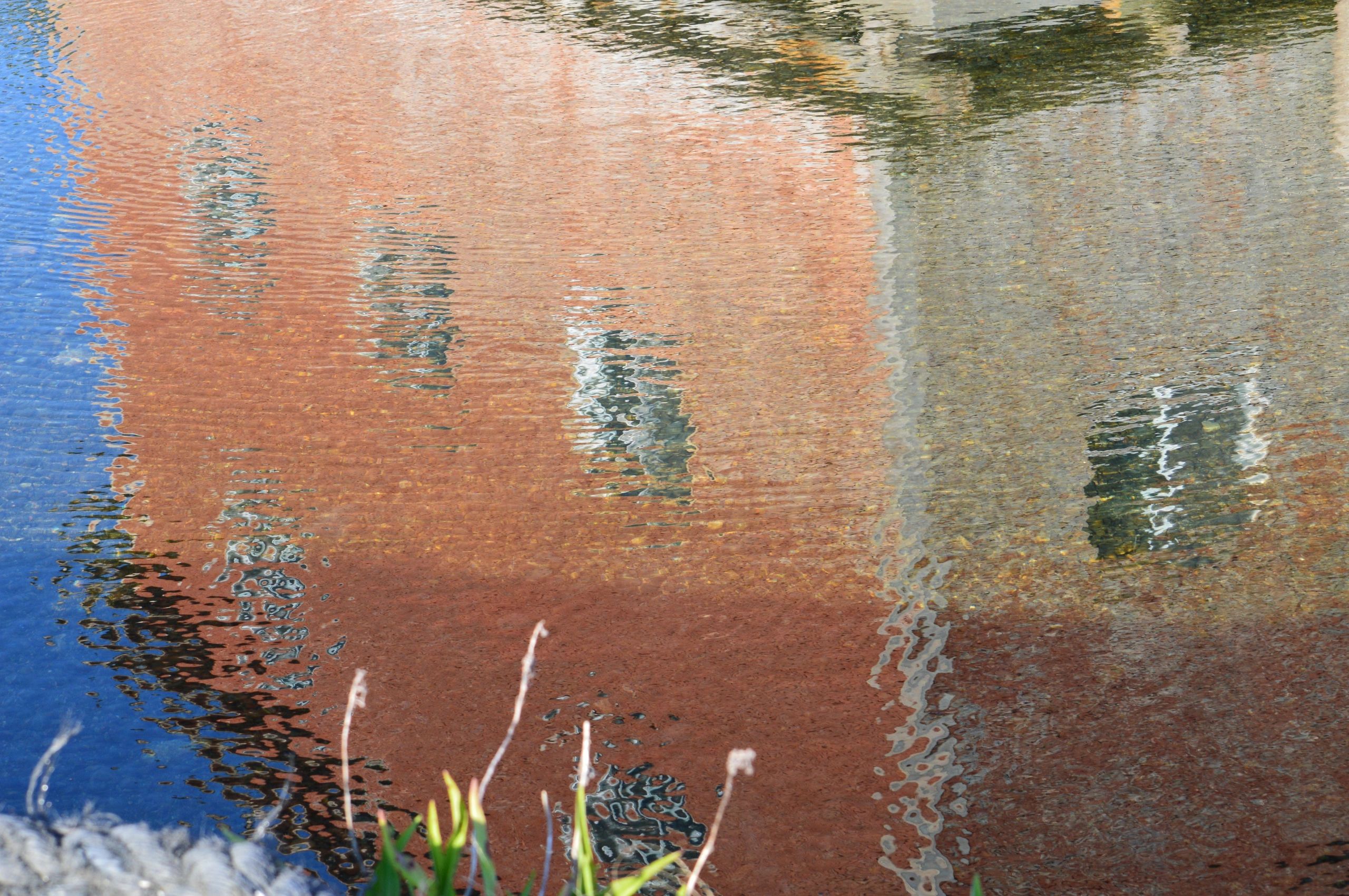 Weathered clapboard building reflected in the crystal waters of Peggys Cove, Nova Scotia