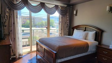Cozy bedroom with wooden furniture and large window.