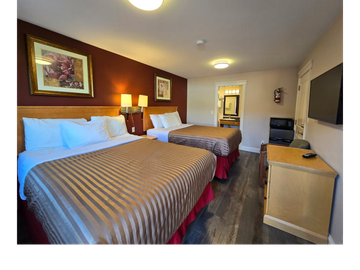 Hotel room with two beds and simple decor.