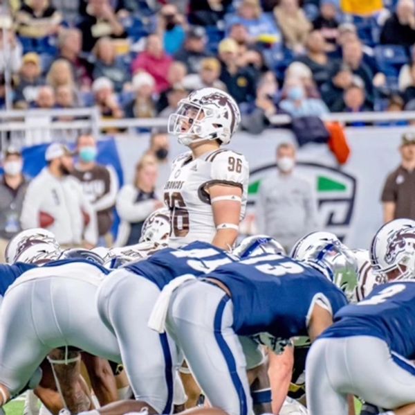 Football players lined up at the line of scrimmage during a game.