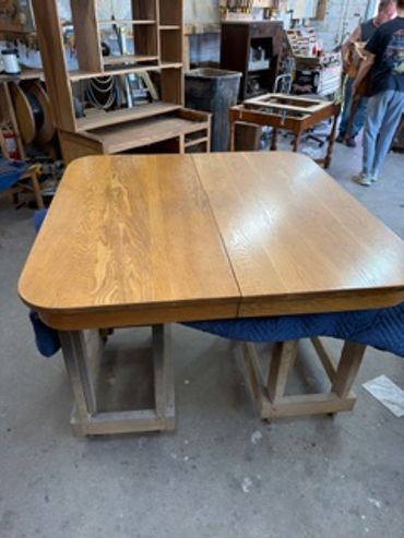 Wooden table being worked on in a workshop.