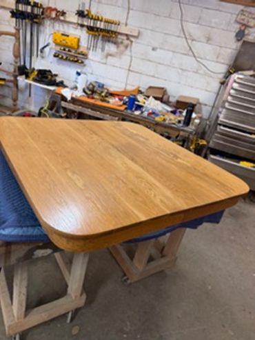 Smooth wooden table top in a workshop setting.