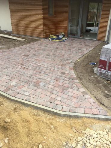 Newly installed brick driveway leading to a modern house entrance.