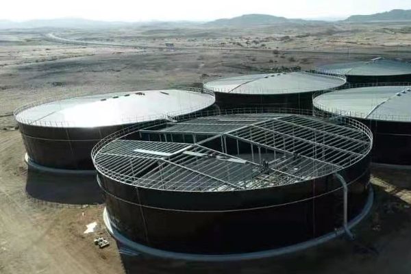 Large circular industrial tanks in a desert area.