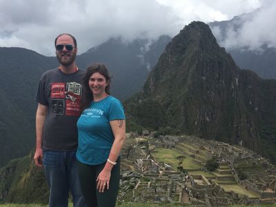 Couple posing at Machu Picchu with mountains in the background.