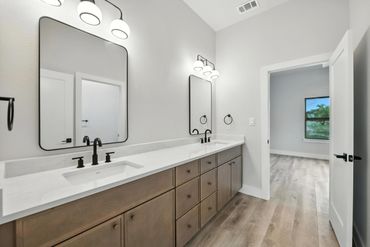 Modern bathroom with double sinks and large mirrors.
