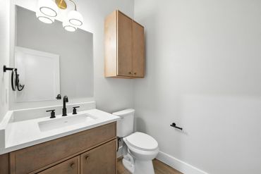 Modern bathroom with wooden vanity and white walls.