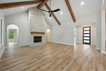 Spacious living room with vaulted ceiling and stone fireplace.