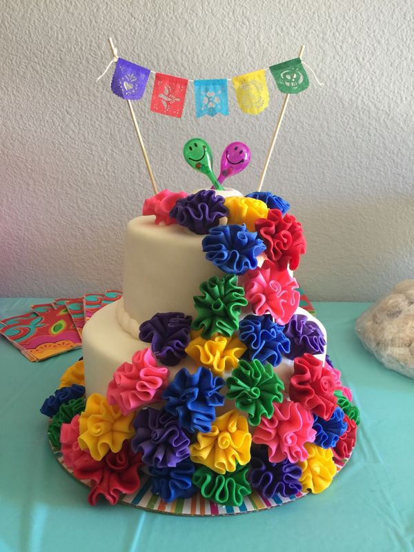 2 tier fiesta cake with multi-colored carnations on side
