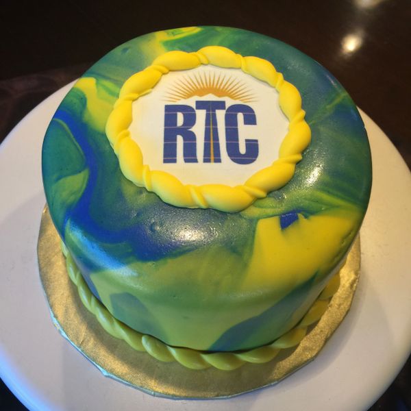 yellow blue and green marbled cake with RTC logo