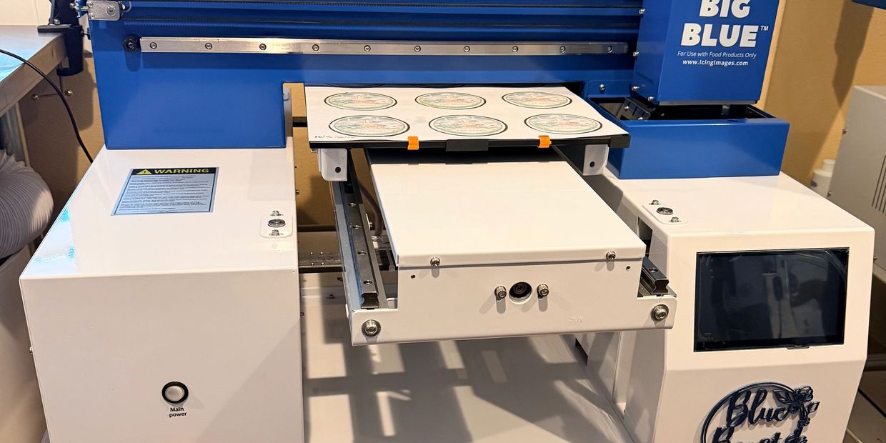 Picture of a blue and white machine that prints on cakes and cookies