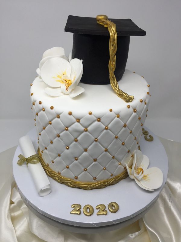 white cake with quilted sides and graduation hat, diploma and orchids 