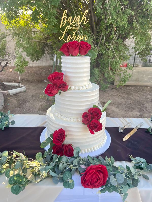 Three tier white cake with red roses.