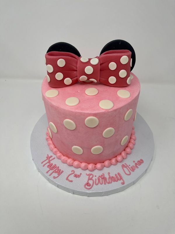 Pink cake with polka dots and a red bow
