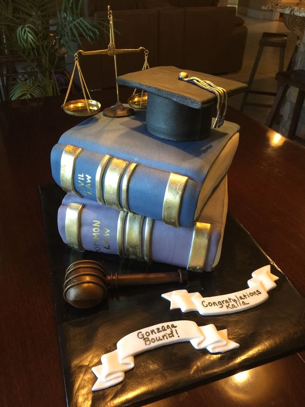 Cake of two books with a graduation hat law scales and gavel