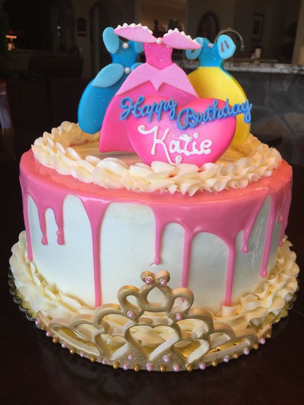 white cake with gold crown and princess dresses on top