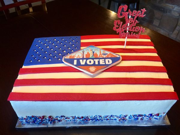Sheet cake with American fondant flag on top with I Voted logo.