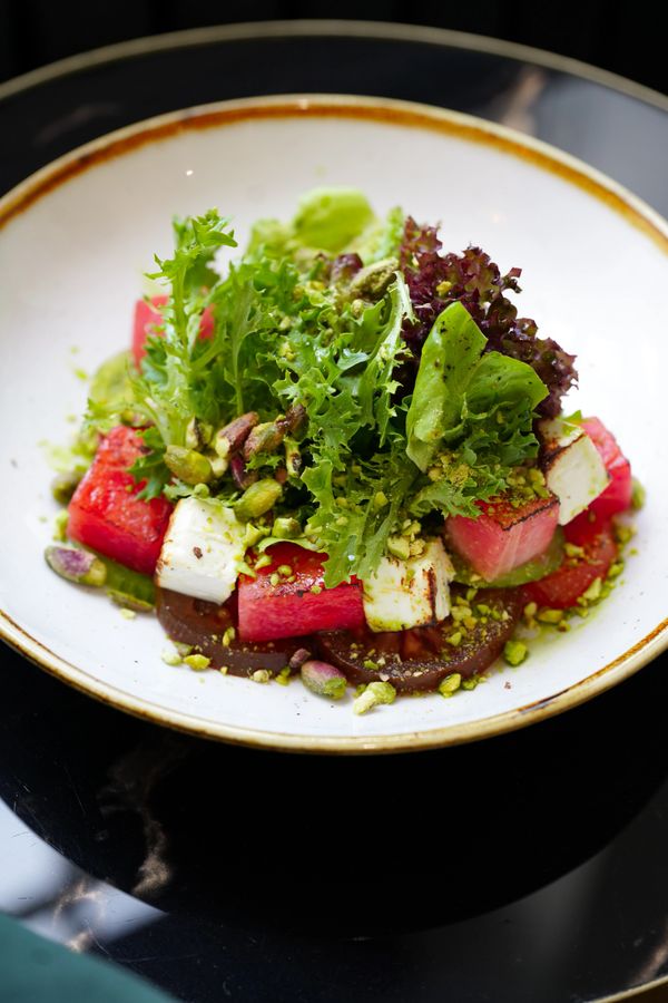 Fresh salad with watermelon, feta, mixed greens, and pistachios.