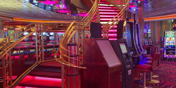 Vibrant casino interior with neon-lit stairs and slot machines.