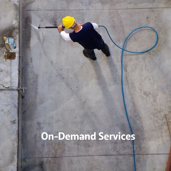 Worker using a power washer on a concrete surface, labeled 'On-Demand Services'.