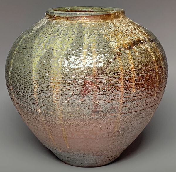 Glazed ceramic vase with earthy tones and textured surface.