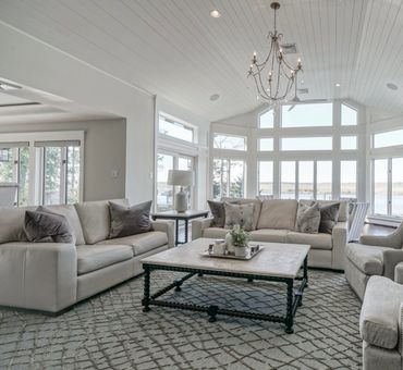 Bright living room with large windows and neutral-toned furniture.