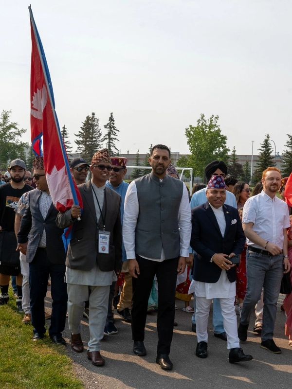 Group of people marching with a Nepalese flag.