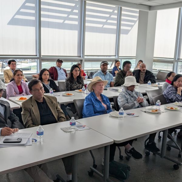 Group of people attending a seminar in a bright room.