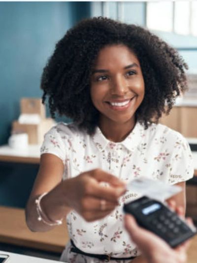 Woman happily paying with a card reader.