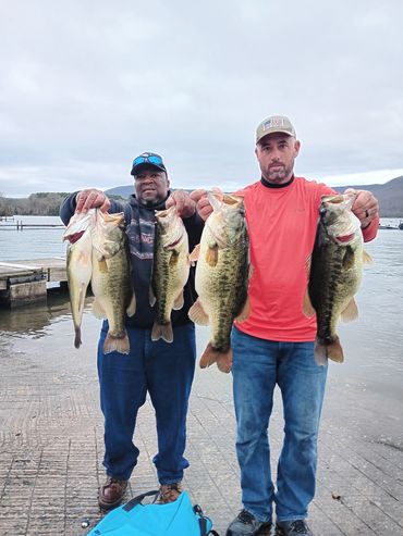 Two fishermen holding five bass