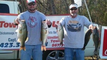 Two fishermen holding five bass