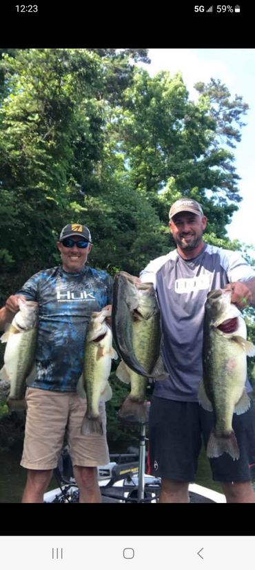 Two fishermen holding five bass