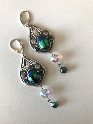 Elegant silver earrings with green and iridescent beads and intricate designs.
